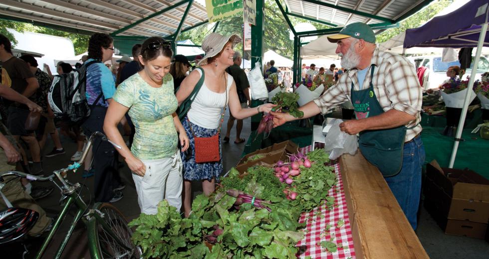 Customers browse the offerings at Davis’s farmers market on Saturday afternoon.