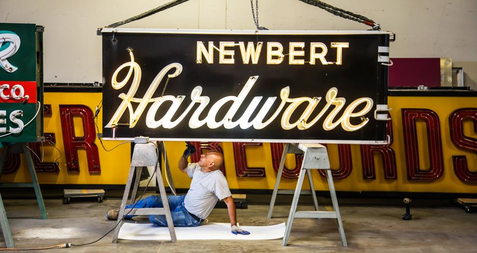 Signs for Newbert Hardware and Tower Records await a tune-up from Pacific Neon electrician Sergio Romero. (Photos by Joan Cusick)
