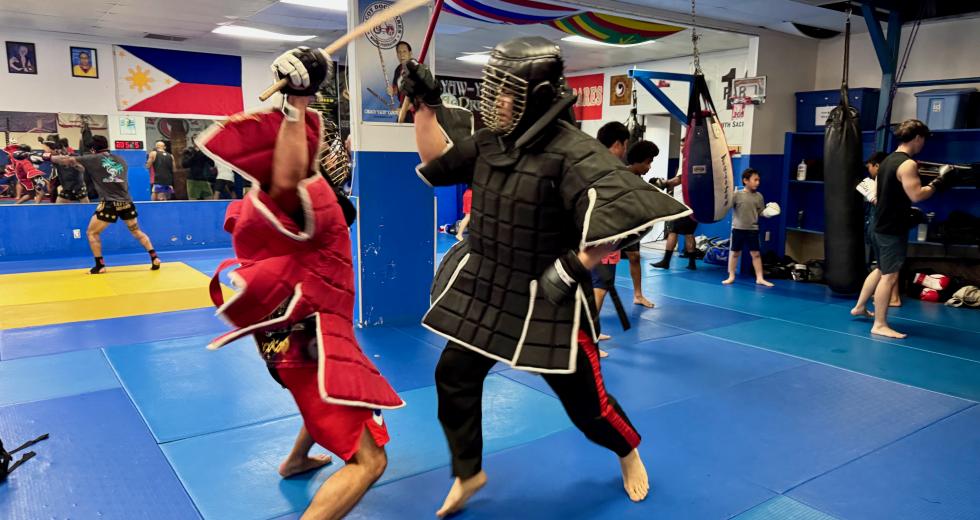 Sacramento eskrimadors Jeremy Mayberry-Antolin, left, and Charley Malagum spar inside the Rancho Cordova Martial Arts Center. (Photo by Scott Thomas Anderson)