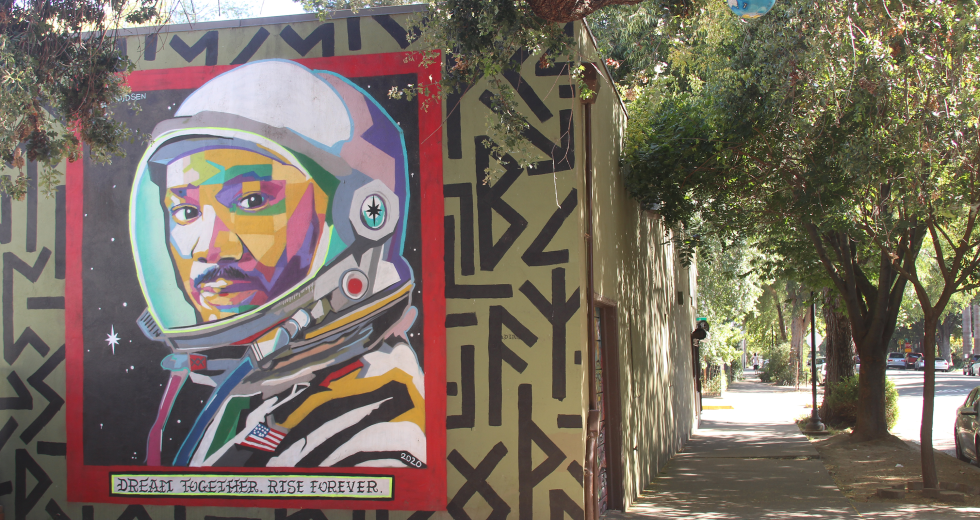 The mural "Dream Together. Rise Forever" was painted by Sacramento artist J.M. Knudsen in 2020 on the side of Peace Market. (Photo by Sonora Slater)