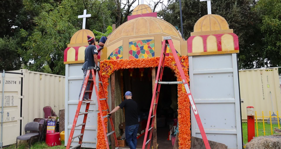 Volunteers hang marigolds at the Latino Center of Arts & Culture's El Panteón. (Photos by Melissa LuVisi)