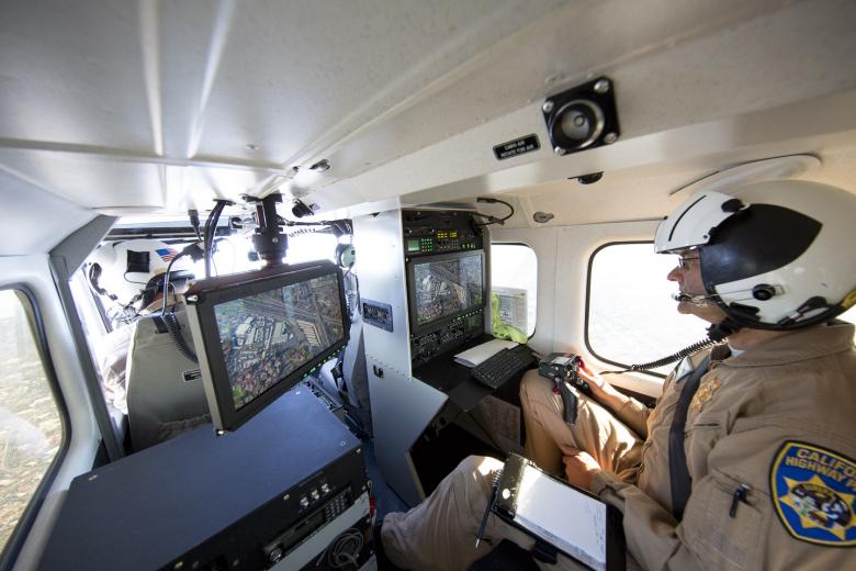 Flight officer Troy Marks operates a large sensor system, with multiple cameras inside of it, that extends from the belly of the aircraft. One camera has a long-distance lens designed specifically for low light, another has a daytime color lens, one is an infrared, heat-detecting camera. Flight officer Troy Marks operates a large sensor system, with multiple cameras inside of it, that extends from the belly of the aircraft. One camera has a long-distance lens designed specifically for low light, another has a daytime color lens, one is an infrared, heat-detecting camera.
