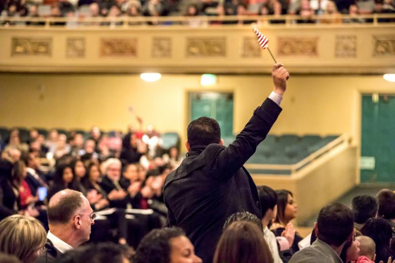 When the list of nations is announced, Khaleel rises and waves his American flag. “It has been my dream since I was a child” to be a U.S. citizen, says Khaleel, who served as an interpreter for the U.S. military in Iraq.