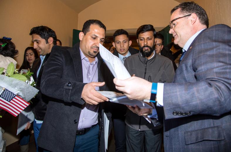 On the way out of the auditorium, Khaleel picks up paperwork to apply for Social Security. Information is also available for passport applications and voter registration.