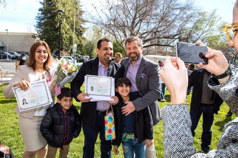 Immediately after the ceremony, the family poses with their sponsor, former 1st Lt. Josh Fjelstad, for whom Khaleel served as a military interpreter in Iraq.