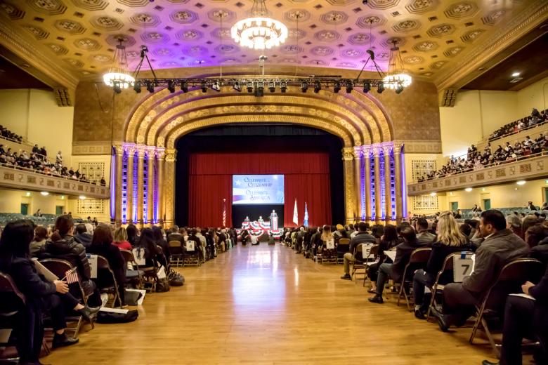 As new citizens file in, they are directed to a designated section on the floor of Memorial Auditorium. Friends and family sit in the upper levels