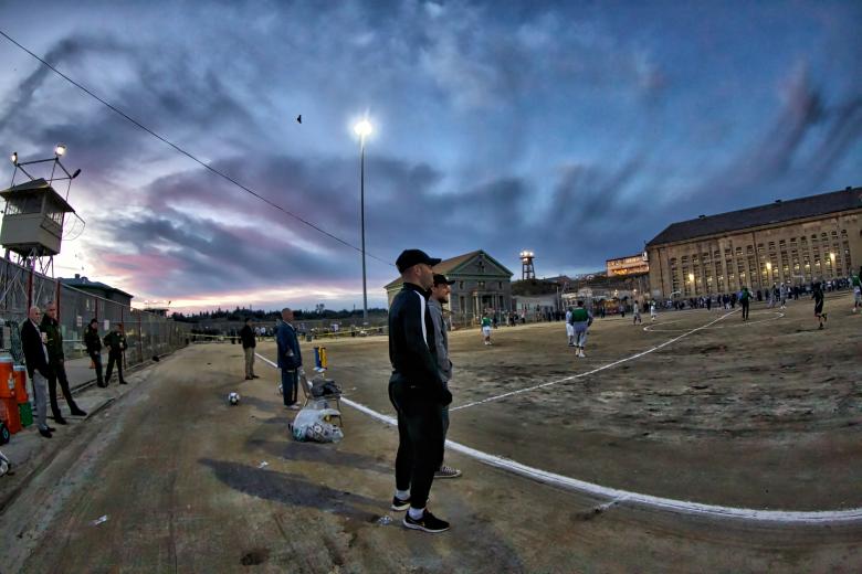 Folsom State Prison at dusk, as Sacramento Republic FC players Sam Werner and Hayden Partain look on during a game. “The administration here has been fantastic. They’ve welcomed us with open arms and worked with us to grow this partnership,” says Todd Dunivant, Republic FC’s general manager (Photo by Steve Martarano)