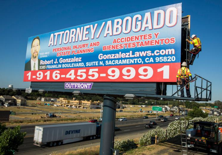 Billboards have been a staple of American advertising since the late 1800s. Originally, crews pasted several strips of posters together to create one large billboard. Now, they use vinyl engineered to withstand harsh weather — the material is waterproof and UV protected. Billboards have been a staple of American advertising since the late 1800s. Originally, crews pasted several strips of posters together to create one large billboard. Now, they use vinyl engineered to withstand harsh weather — the material is waterproof and UV protected.