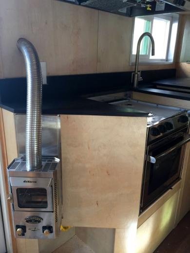 The kitchen area includes paperstone countertops and a 3 burner Marine stove with a propane-powered oven and furnace The kitchen area includes paperstone countertops and a 3 burner Marine stove with a propane-powered oven and furnace