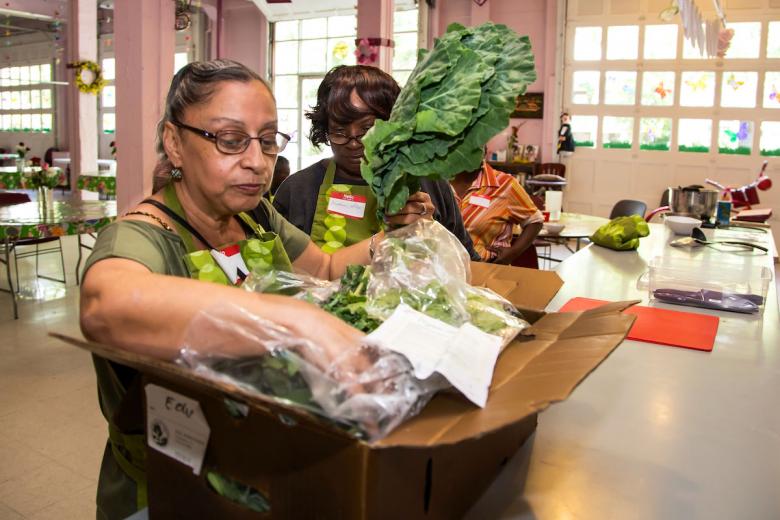 Vivian Walthall checks out the Soil Born Farms CSA box, which she won in a raffle at the Co-Op Community Kitchen. Fredonia Phillips (right) also won a bag with all ingredients for the day’s dish, and every participant took home food samples. Vivian Walthall checks out the Soil Born Farms CSA box, which she won in a raffle at the Co-Op Community Kitchen. Fredonia Phillips (right) also won a bag with all ingredients for the day’s dish, and every participant took home food samples.