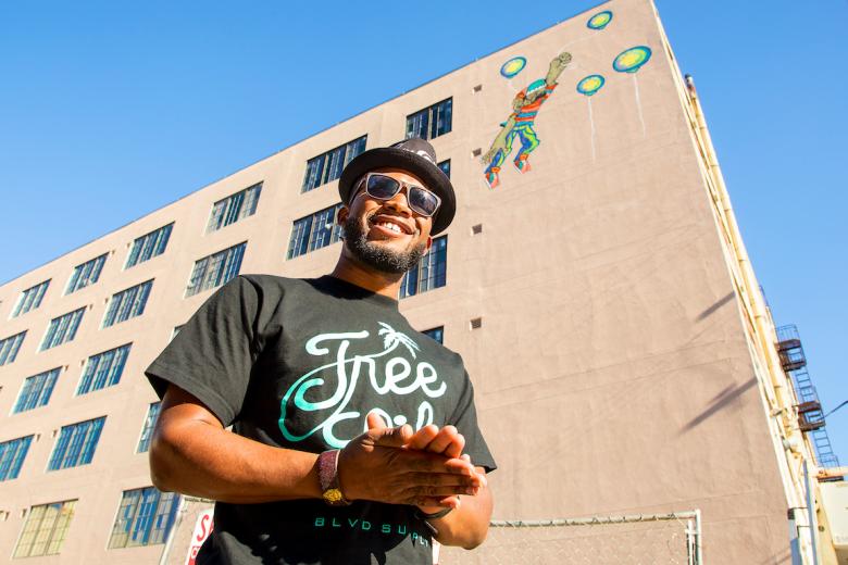 Demetris Washington, known as BAMR, shows off his painting along 11th St — he'll also create a mural for the underground parking garage Demetris Washington, known as BAMR, shows off his painting along 11th St — he'll also create a mural for the underground parking garage