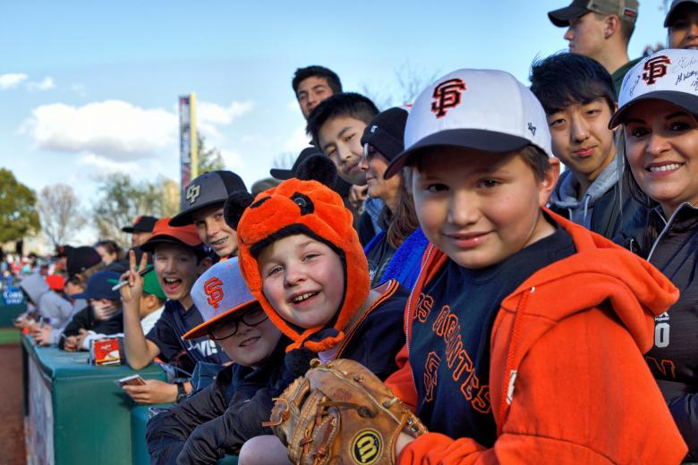 Fans wait along the first base line for Giants players to sign autographs before Saturday’s game.