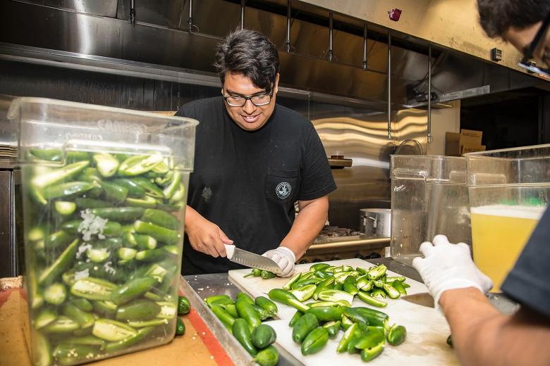 Lopez and Roque prep jalapenos for the hot sauce recipe. They have been with the Sangre del Dragon project since its inception in August 2016 at Sac High.