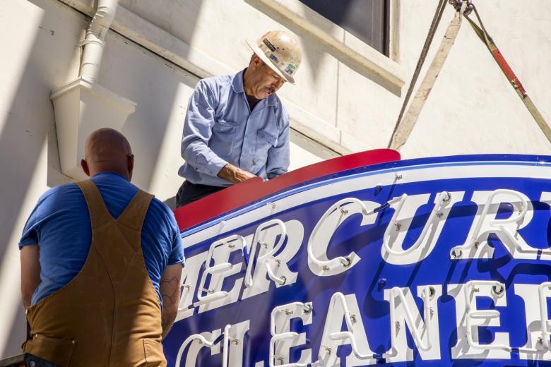 The same crew from Pacific Neon rehung the sign in its new home on the Legado de Ravel building. The same crew from Pacific Neon rehung the sign in its new home on the Legado de Ravel building.