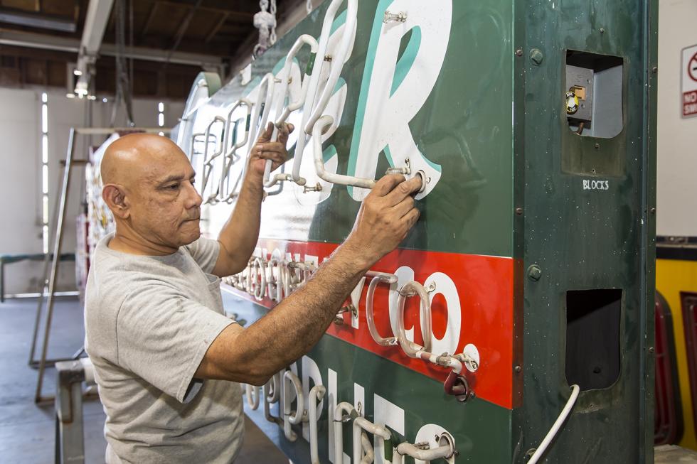 Pacific Neon electrician Sergio Romero removes the neon tubes on the Sleeper Stamps & Stationery sign.
(Photos by Joan Cusick)