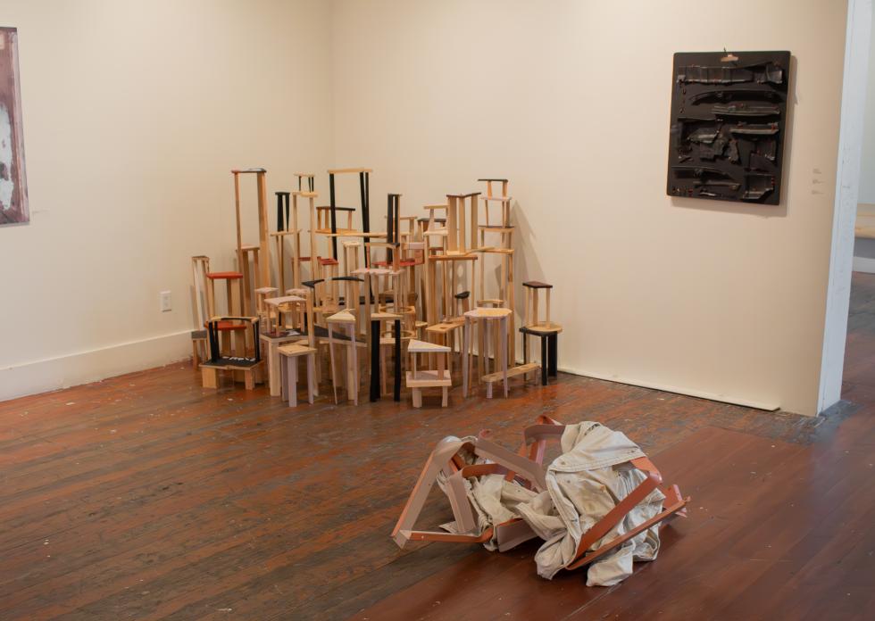 Works like "Wrapped Up" (foreground), "Fixed Up" (background) and "Hung Up" (on wall) use scrap materials and abstract shapes.