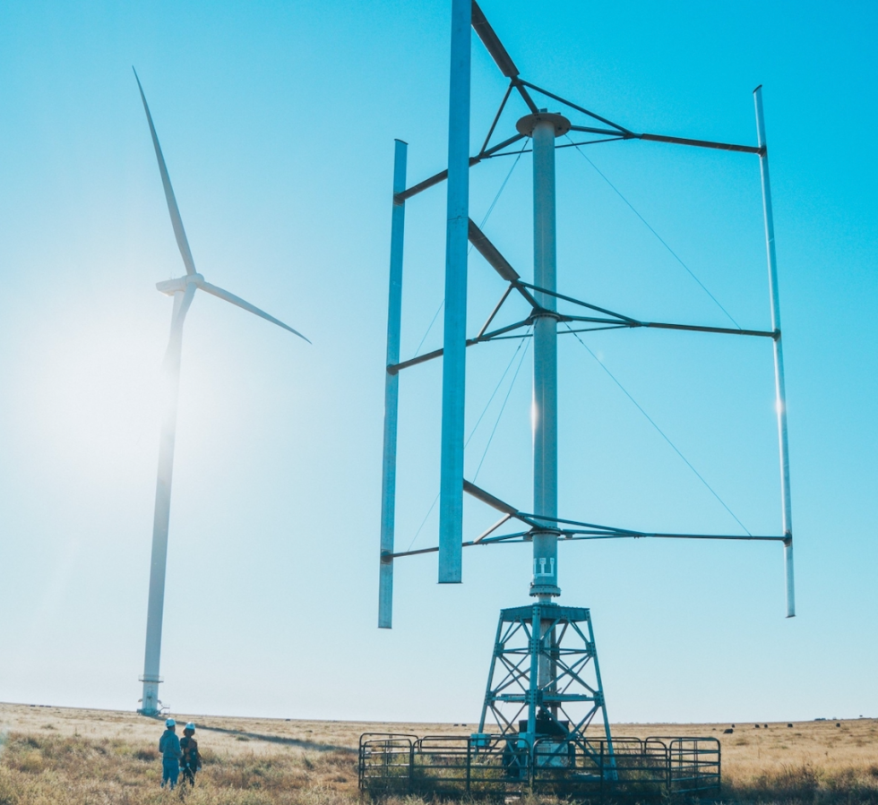 Kevin Wolf stands in front of a vertical axis wind turbine. (Photo courtesy of Wind Harvest)